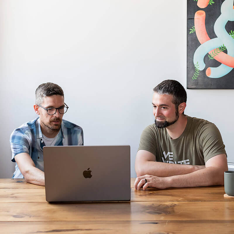 Two developers talking over a laptop